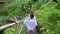 Travelling in Bali. Woman in dress walking in tropical forest park.