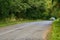 Travelling by car. Asphalt road among summer fields of green plantings