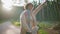 Travelling girl catching car on road sunlit forest holding map. Woman tourist