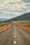 Travelling Iceland in Autumn. Amazing view of empty road passing through beautiful landscape in Iceland, dramatic cloudy