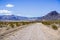 Travelling on an unpaved road through a remote area of Death Valley National Park; Racetrack Playa, mountains and blue sky in the