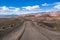 Travelling on an unpaved road through a remote area of Death Valley National Park; Ubehebe crater area in the background;