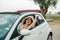 Travelling woman holding keys to new car and smiling at camera - ownership and purchase automobile concept