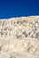 The Travertine pools and terraces in Pamukkale, Turkey. Desert sand with curvy pattern texture against a blue sky