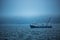 Trawler fishing boat sailing in open waters on a cold and foggy