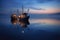 trawlers reflection on calm sea surface at twilight