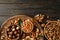 Tray with bowls with different nuts on wooden background