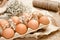 A tray of brown fresh hen`s eggs on wrinkled craft paper.