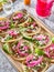 Tray of carne asada tacos topped with pickled onions and cojita cheese