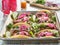 Tray of carne asada tacos topped with pickled onions and cojita cheese