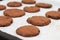 Tray of chocolate cacao chia seed cookies stacked on white parch