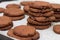 Tray of chocolate cacao chia seed cookies stacked on white parch