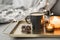 Tray with coffee in a black mug, burning aroma candles and decorative pine cones