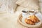 Tray with coffee cup, croissants, muesli and white flowers