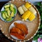 Tray of food for quick vegan lunch, cheap and simple meal with boiled corn, sweet potato, avocado