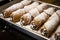 a tray of freshly filled cannoli with a dusting of powdered sugar