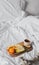 Tray with fruits and cup of tea in white clean bed. Mindful and quiet living, slow life, bed in breakfast concept, simple