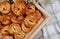 A tray of homemade traditional buns, the yellow buns have raisins and cinnamon