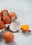 Tray with organic brown eggs with yolk on light kitchen background