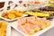 Tray of sliced cake with pink icing on a buffet