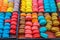 Trays of multicolored and sweet macarons in French patisserie