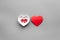 Treat heart. Pills in bowl in shape of heart on grey background top view copyspace