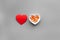 Treat heart. Pills in bowl in shape of heart on grey background top view copyspace