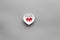 Treat heart. Pills in bowl in shape of heart on grey background top view copyspace