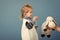 Treatment of children. Boy play veterinarian with toy sheep in mothers hand