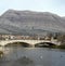 Trebinje town Stone bridge over river with ducks on water surface and hight rocky mountains at background