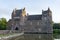 Trecesson Castle reflected in the pond and surrounded by forest