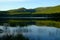 Tree covered mountain reflected in calm waters