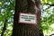 Tree in the forest with warning signboard about danger of fire