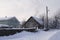 Tree and house in snow in countryside