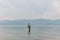 Tree in Lake Erhai, with mountains covered in clouds in the distance, in Dali, Yunnan, China