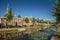 Tree-lined canal with boat, church bell tower and brick houses at the bank on sunset in Weesp.