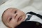 Tree months old newborn baby boy dressed like businessman with bow tie, face expresion