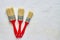 Tree paintbrushes with red handles on freshly made concrete background. Repairing concept. Top view with copy space