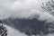 Tree silhouette and rain over forest mountains.