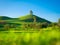 Tree on top of the hill. Landscape before sunset. Fields and pastures for animals. Agricultural landscape in summer time.