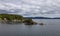 Treed Island with Homes, boats and docks, nearby smaller island with lighthouse