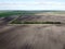 Trees along an irrigation canal on a plowed field top view. Farmland