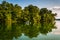 Trees and boat reflecting in Loch Raven Reservoir, near Towson,