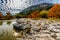 Trees with Fall Foliage on a Rocky Bank of the Frio River with Hill in Background