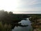 Trees and fields on the sandy shore of the lake. Calm northern latitudes.