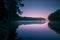 Trees reflecting in water smooth surface at sunrise