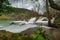 Trees rising from flowing water at Beautiful Krka waterfalls wooden pathways viewed from the path in cold winter setting. No