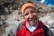 Trekker with burned skin on face is smiling at camera in Khumbu