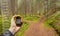 A trekker is finding the right position in the forest via gps in a cloudy autumnal day