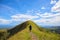 Trekker goes on the top of hill in the mountains. Tourist travels through the mountains. Mountain landscape